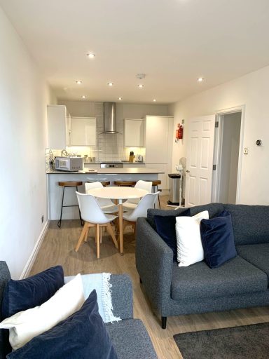 Modern open-plan living space with kitchen, dining table, and comfortable seating.